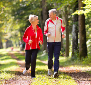 Stock photo of older couple walking in a park; illustrating that they do not suffer from painful vein conditions any longer.