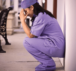 Photo of a healthcare worker tired from being on her feet all day, suffering with vein disorder.